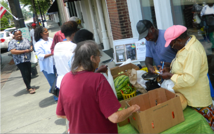 people getting vegetables outside