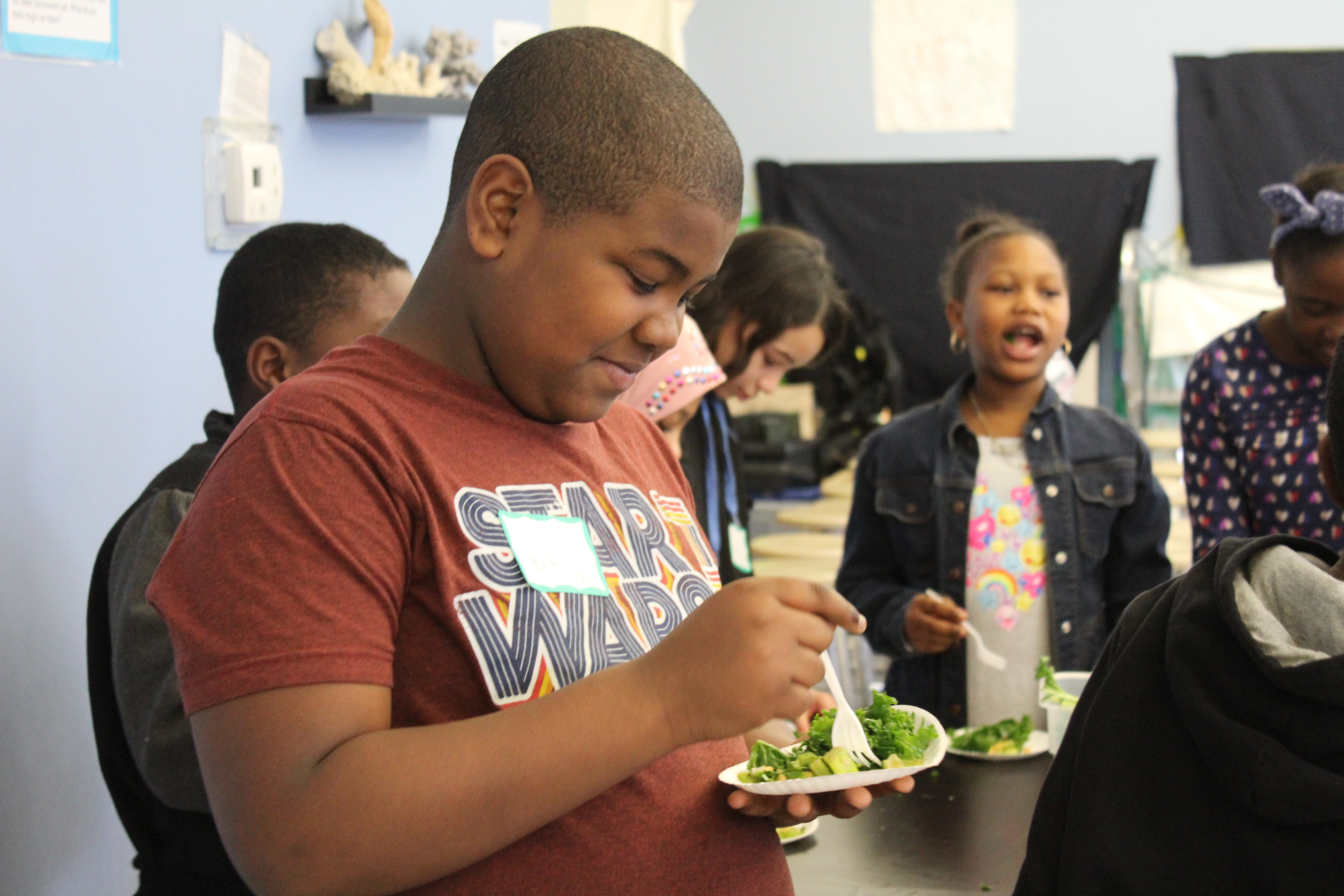a boy eats a sample of salad