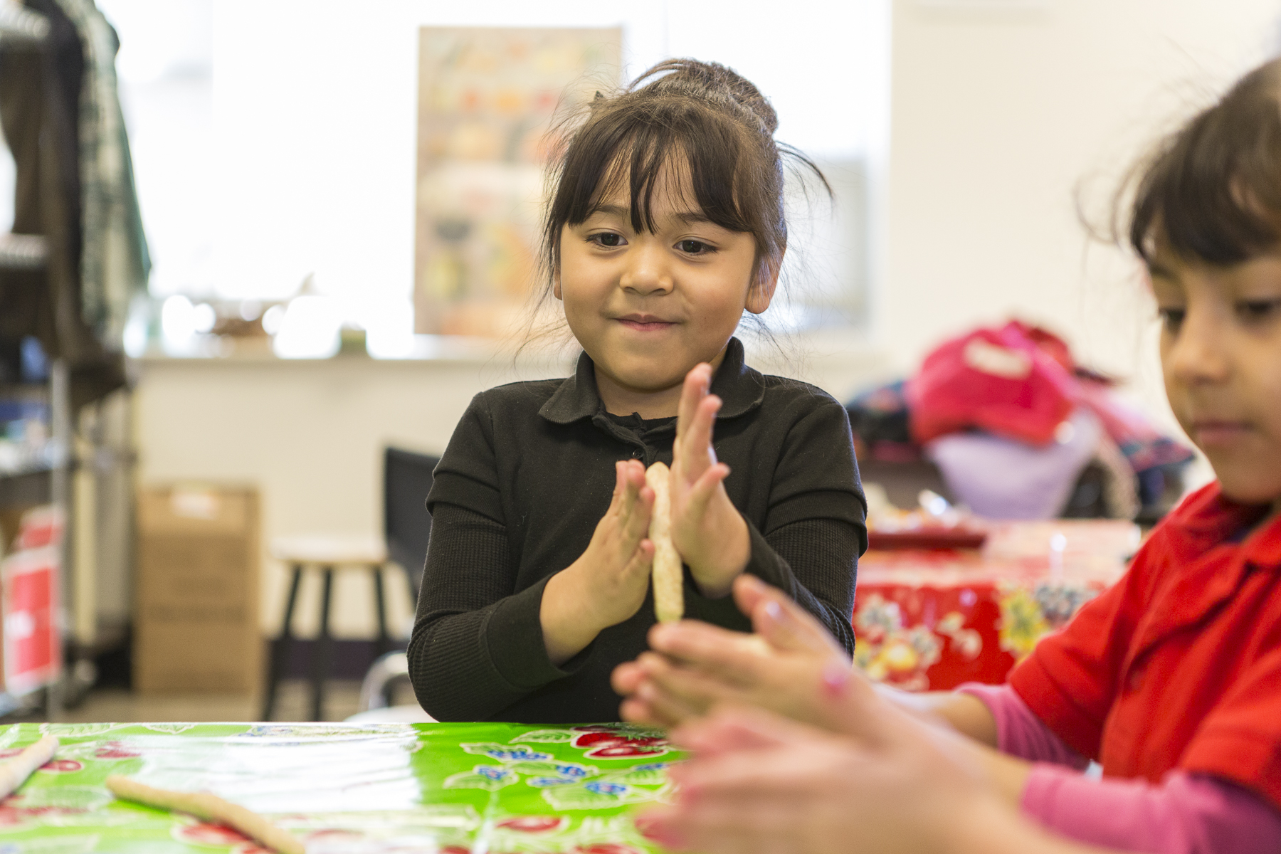 a girl rolling dough with her hands