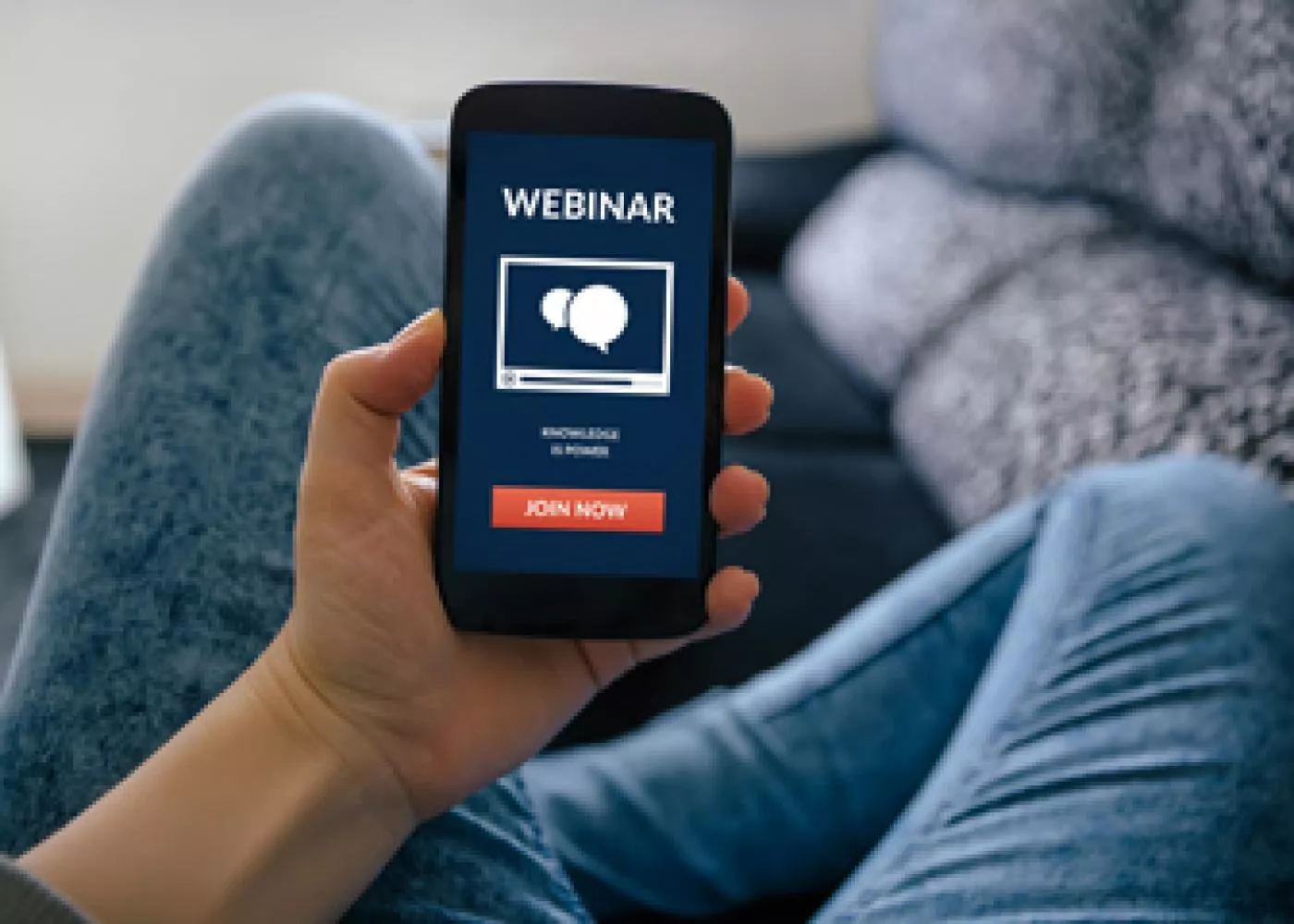 person watching a webinar on a phone