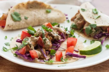 fish tacos on a plate with lime garnish
