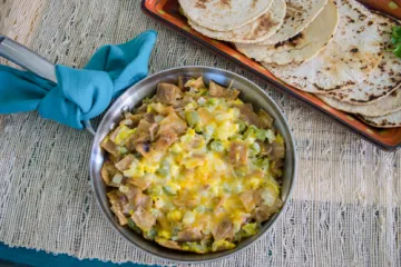 Eggs, tortillas, pepper, onion, and cheese in a skillet
