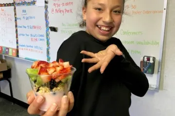 a girl holds a yogurt parfait