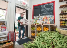 Man bringing produce into shop