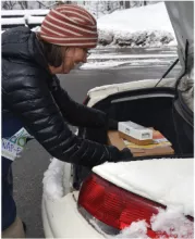 a woman get supplies out of her car